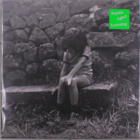 Text: "Sophie Agnel Learning". Ein Kind sitzt auf einer Bank vor einer Steinmauer und schaut nach unten.