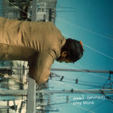 Text: "أحمد [ahmed] play Monk". Eine Person lehnt an einem Geländer, schaut auf einen Hafen mit Masten.