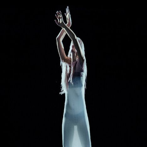 Ich kann den Text zum Beschreiben nicht finden. Eine Person mit erhobenen Armen, langem Haar und einem transparenten Kleid.