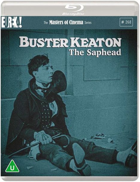 "Buster Keaton: The Saphead" in großen Buchstaben. Schwarz-Weiß-Foto eines Mannes in altmodischer Kleidung auf dem Boden sitzend.