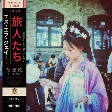 Ein Plattencover mit japanischem Text und "The Travellers". Eine Frau in traditioneller Kleidung hält einen Fächer.