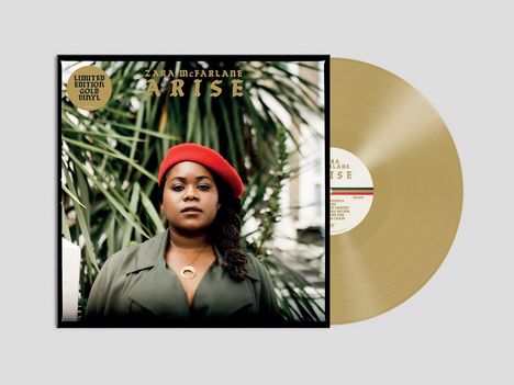 „Limited Edition Gold Vinyl. Zara McFarlane Arise.“ Frau mit rotem Barett vor tropischen Pflanzen, goldene Schallplatte.