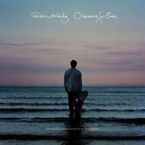 "Robin Katz Oceans for Eros" und "Orchestral Arrangements by Guy Barker". Ein Mann steht mit Gitarrenkoffer im Wasser bei Sonnenuntergang.