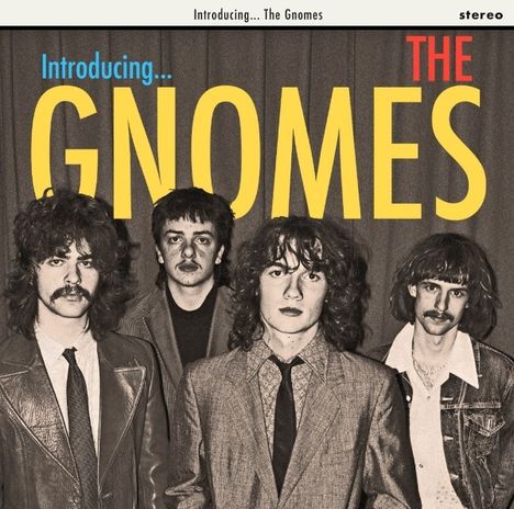 Introducing... THE GNOMES. Vier Männer mit langen Haaren und Anzügen stehen vor Vorhängen. Vintage-Stil.