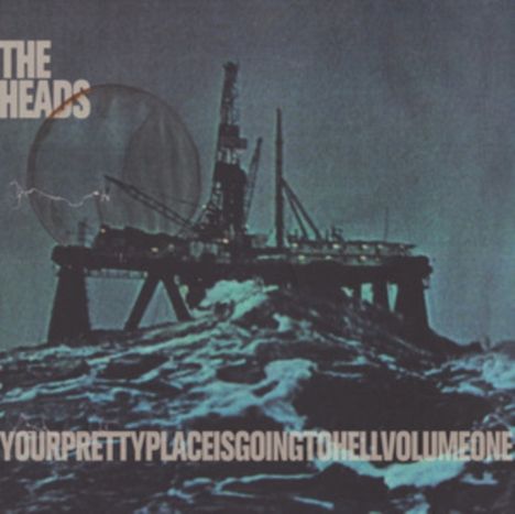 Text: "THE HEADS" und "YOURPRETTYPLACEISGOINGTOHELLVOLUMEONE". Dunkle Bohrinsel vor stürmischem Meer, düstere Stimmung.
