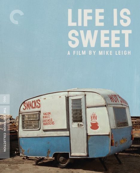 Oben steht „LIFE IS SWEET A FILM BY MIKE LEIGH“. Ein blauer Wohnwagen mit Texten wie „SNACKS“ und „HOT SNACKS“.