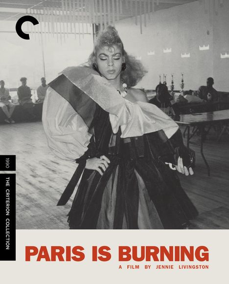 "Paris is Burning" steht im Vordergrund, eine Person in auffälliger Kleidung tanzt, umgeben von Zuschauern und Pokalen.