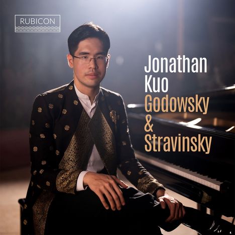 Text: "RUBICON", "Jonathan Kuo Godowsky & Stravinsky". Ein Mann in elegantem Outfit sitzt am Flügel, ernst blickend.