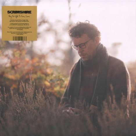 „SCRIMSHIRE“ steht oben links auf einem beigen Quadrat. Darunter steht ein Mann mit Brille in einer herbstlichen Landschaft.