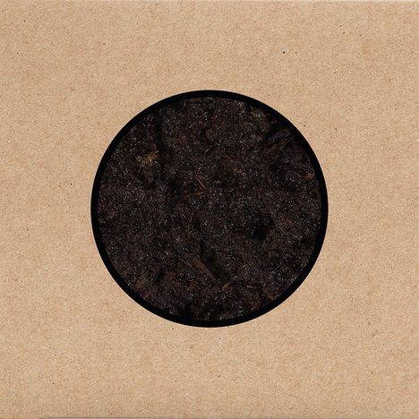 Runde Aussparung in brauner Verpackung zeigt dunkle Erde oder Torf.