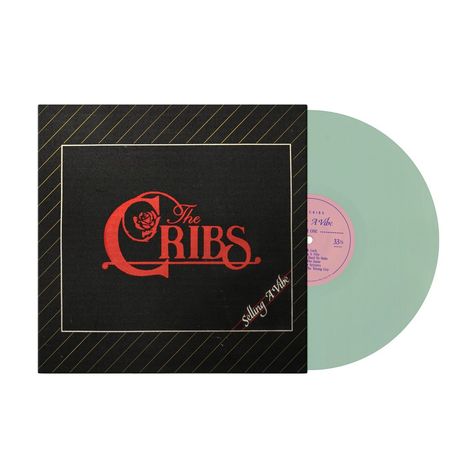 Schwarzes Cover mit rotem Text "The Cribs" und "Selling A Vibe". Grüne Schallplatte mit rosa Label rechts daneben.