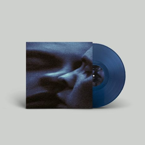 Eine blaue Vinyl-Schallplatte mit einem Cover zeigt Nahaufnahme zweier Gesichtshälften, die sich fast berühren.