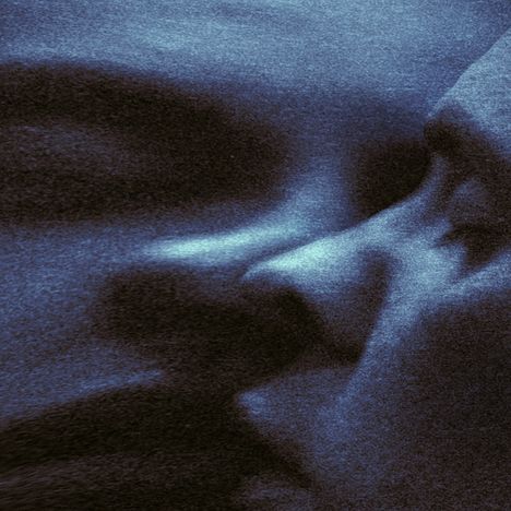 Eine blau verfärbte Nahaufnahme eines Gesichts mit abstrakter, körniger Textur.