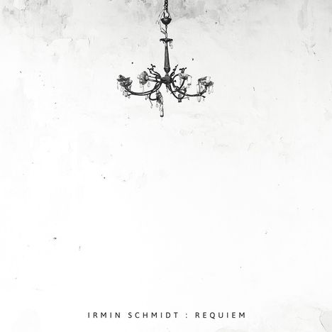 Text: "IRMIN SCHMIDT: REQUIEM". Ein schwarzer Kronleuchter hängt vor einer schlichten, strukturierten weißen Wand.