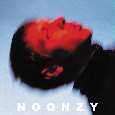 Text "NOONZY" in Weiß. Ein verschwommenes Gesicht, rot beleuchtet, mit blauem Hintergrund.