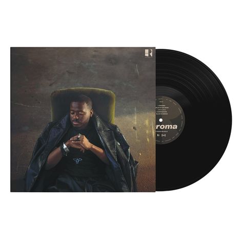 Eine Schallplatte neben einem Albumcover mit einem nachdenklichen, in einen Mantel gehüllten Mann auf einem Stuhl.