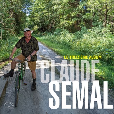 „Le treizième album“ und „Claude Semal“ in großen Buchstaben. Ein Mann auf einem Fahrrad auf einem Waldweg, fröhlich lächelnd.
