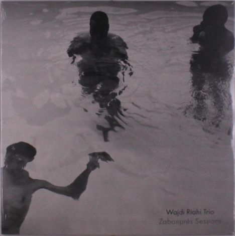 "Wajdi Riahi Trio, Zabonprés Sessions" steht unten rechts. Drei Personen schwimmen in einem seichten Gewässer. Schwarzweiß.