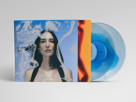Auf einem blauen Hintergrund steht eine Frau mit dunklen Haaren. Links und rechts sind ein oranger Streifen und eine blaue Vinyl-Schallplatte zu sehen.