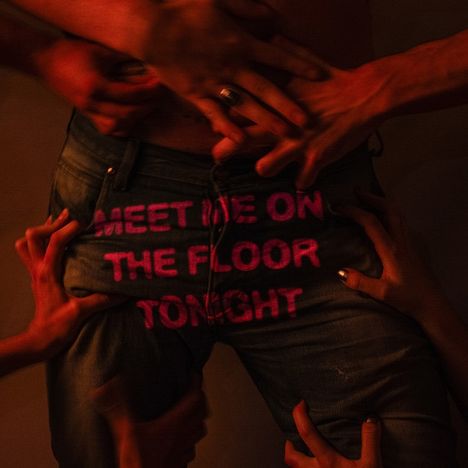 „MEET ME ON THE FLOOR TONIGHT“ steht in pinken Buchstaben auf einer Jeans. Viele Hände greifen nach der Jeans.