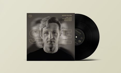 Text: "Jesper Thorn, STILLE." Schwarze Schallplatte mit einem Cover, das das Porträt einer Person zeigt.