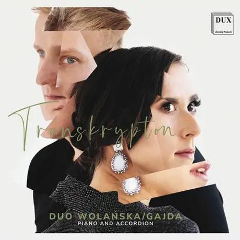 Text: "Transkrypton. DUO WOLANSKA/GAJDA PIANO AND ACCORDION." Collage von zwei Gesichtern, männlich und weiblich. Logo oben rechts: "DUX".