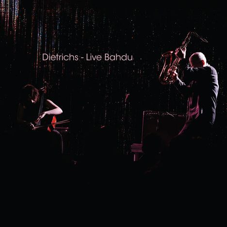Text: "Dietrichs - Live Bahdu". Zwei Musiker spielen Saxophon und Cello, umgeben von schummrigen Lichtern.