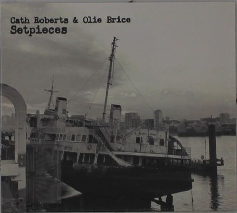 Text: "Cath Roberts & Olie Brice Setpieces". Schwarz-weißes Foto eines alten, verfallenen Schiffs am Wasser vor Stadt-Skyline.