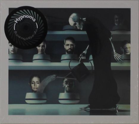 "Hypnoma" steht auf einem spiralförmigen Element. Eine Skelettfigur gießt Köpfe in Töpfen auf einem Regal.