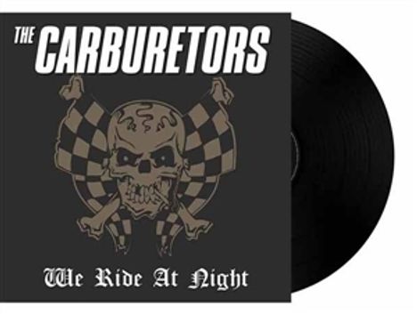 Text: "The Carburetors" oben, "We Ride At Night" unten. Illustration eines Skelettkopfes mit karierten Flaggen.