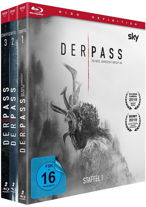 "Der Pass: Die rote Jahreszeit bricht an", "FSK ab 16 freigegeben", "Staffel 1". Schwarze Statue vor nebligem Wald.