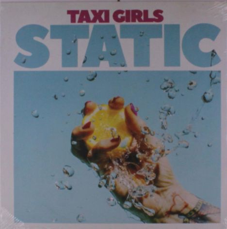 "Taxi Girls STATIC": Eine Hand drückt eine Zitrone, umgeben von spritzendem Wasser auf hellblauem Hintergrund.
