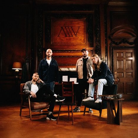 Mittelgroße römische Zahl "XIV" auf einem hölzernen Wandpaneel. Vier Männer in einem holzgetäfelten Raum.