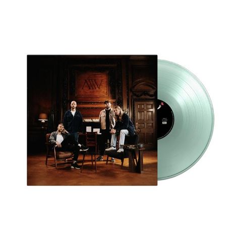 „MW“ an der Wand. Vier Männer in eleganter Umgebung. Durchsichtige Vinylplatte rechts daneben.
