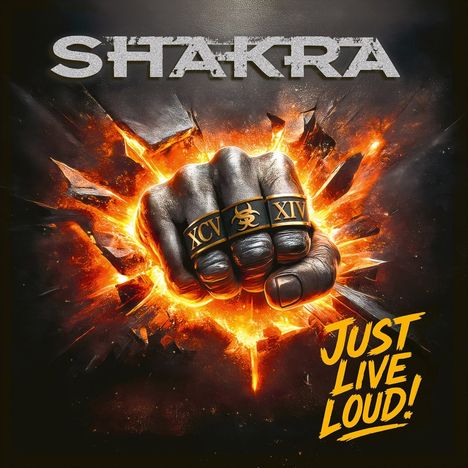 "SHAKRA" oben, "JUST LIVE LOUD!" rechts unten. Faust mit Ringen in Explosion, Ringe mit "XCV" und "XIV".