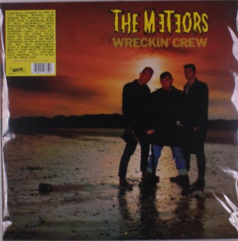 "The Meteors Wreckin' Crew" steht oben. Drei Personen posieren bei Sonnenuntergang vor einer Wasserlandschaft.