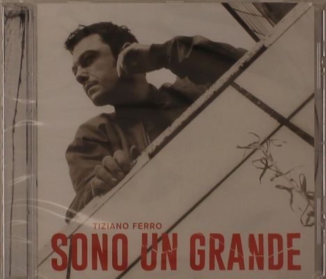 Text: "Tiziano Ferro SONO UN GRANDE". Schwarz-weiß, Mann lehnt auf Geländer, schaut nachdenklich.