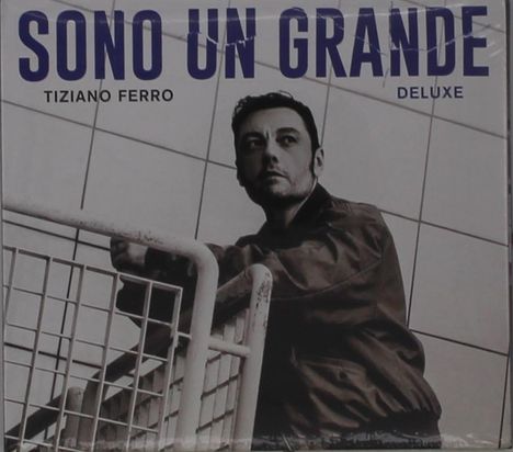"Sono Un Grande" oben, darunter "Tiziano Ferro" und "Deluxe". Ein Mann blickt ernst und lehnt an einem Geländer.