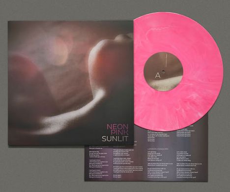 NEON PINK SUNLIT. Eine Schallplatte in Pink mit einem mystischen Foto und Songtexten.