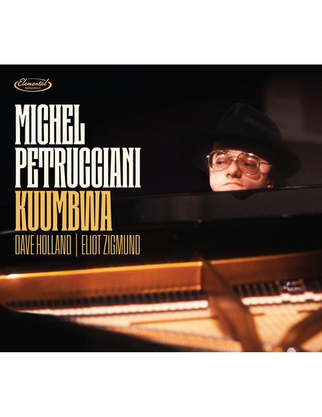 "MICHEL PETRUCCIANI KUUMBWA DAVE HOLLAND ELIOT ZIGMUND" vor dunklem Hintergrund. Ein Mann mit Hut am Klavier.