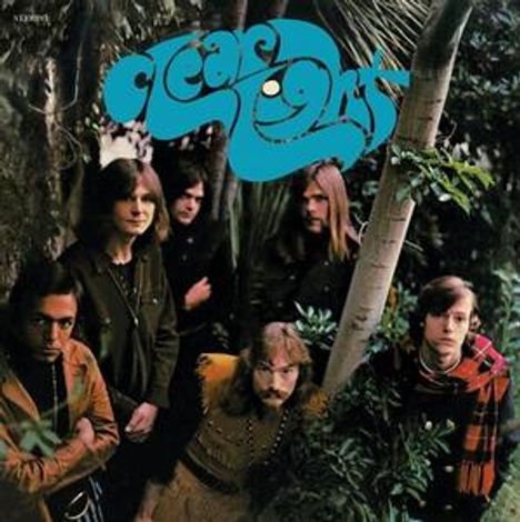 „Ocean's 21“ in blauer, verschnörkelter Schrift. Sechs Männer stehen in einem dichten, grünen Dschungel.