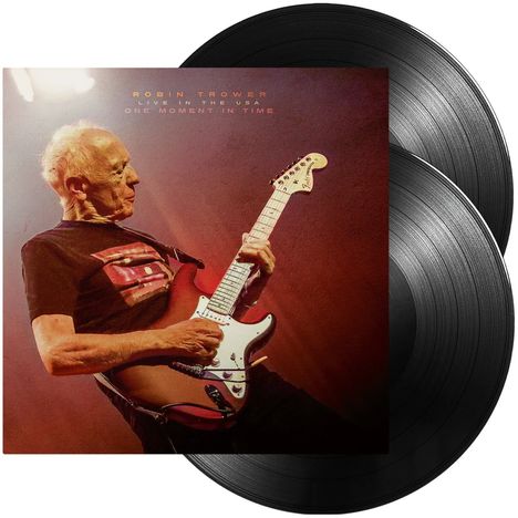 Text: "Robin Trower Live in the USA One Moment in Time". Ein älterer Mann spielt E-Gitarre und zwei Vinyl-Schallplatten.