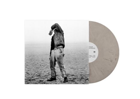 Text: "On Earth", "Mountains", "Colors". Eine Person steht am Strand, den Arm vor dem Gesicht. Schallplatte: graue Marmorierung.