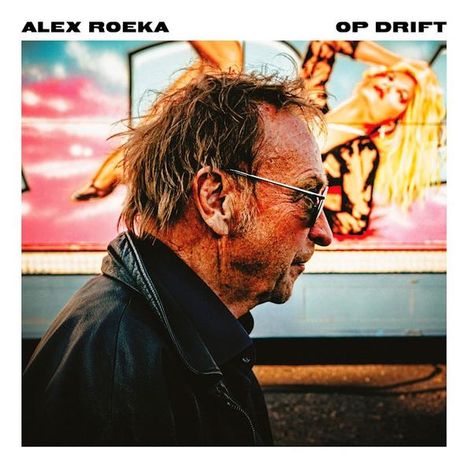 ALEX ROEKA, OP DRIFT. Ein Mann in einer Lederjacke seitlich mit einem Retro-Poster im Hintergrund.