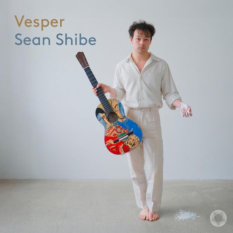 „Vesper, Sean Shibe.“ Ein Mann in Weiß hält eine bunt gestaltete Gitarre, neben ihm eine weiße Substanz am Boden.
