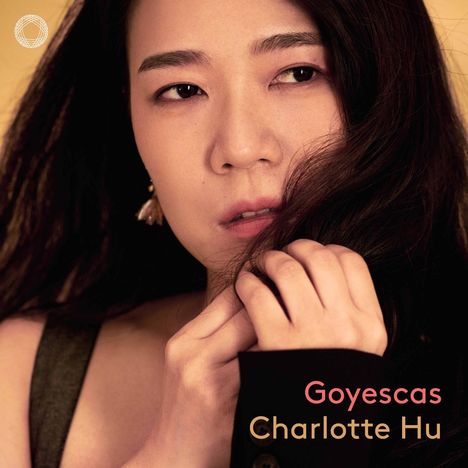 Text: "Goyescas", "Charlotte Hu". Eine Frau schaut nachdenklich, spielt mit ihrem Haar, Hintergrund in warmen Tönen. Oben links ist ein weißes Logo.