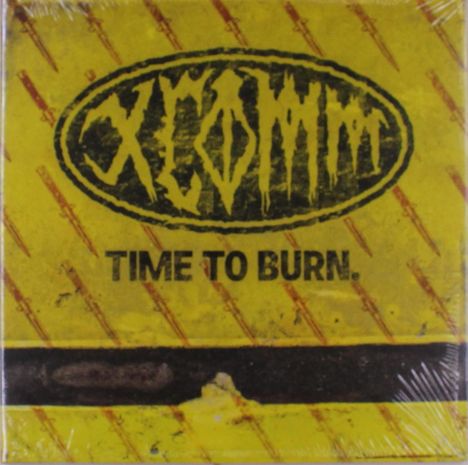 „TIME TO BURN.“ Ein ovales Logo mit stilisiertem Text „XCOMA“ auf gelbem Hintergrund mit diagonalen Linien.