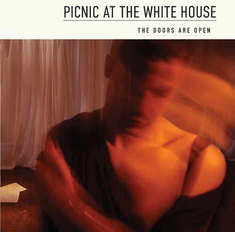 „PICNIC AT THE WHITE HOUSE“ und „THE DOORS ARE OPEN“. Verschwommene Person in warmem Licht vor Vorhang; Noten am Boden.
