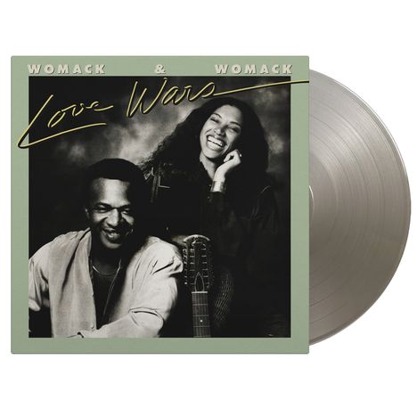 Text: "WOMACK & WOMACK Love Wars". Zwei fröhlich lachende Menschen und eine Gitarre. Plattenhülle mit Schallplatte.