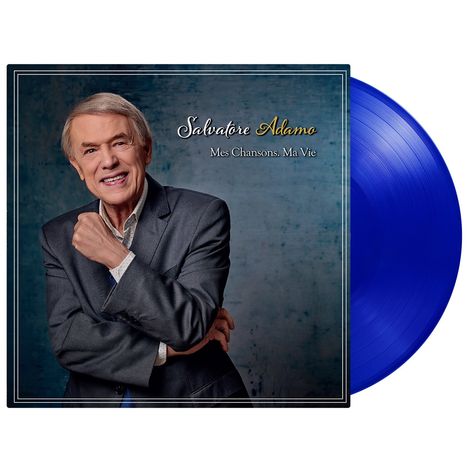 Der Text „Salvatore Adamo – Mes Chansons. Ma Vie“. Ein Mann in Anzug lächelt, daneben eine blaue Vinyl-Schallplatte.